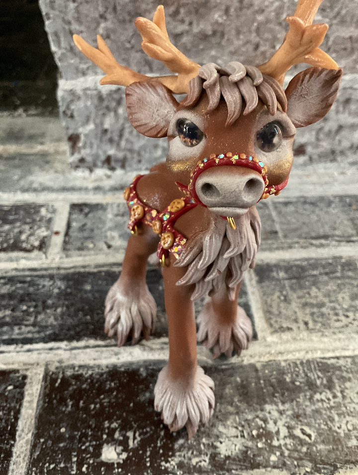 Brown reindeer with harness for sled