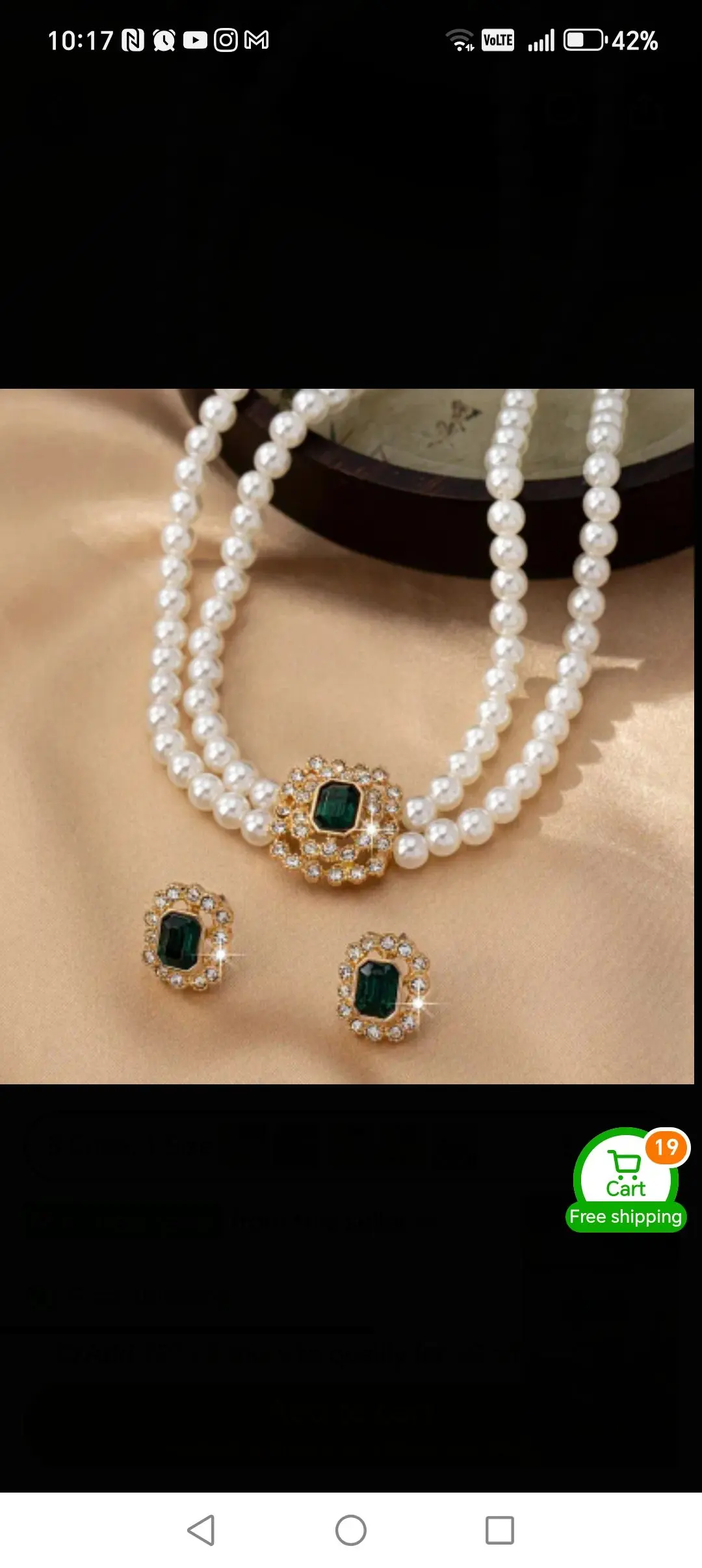 Green embreled stone with white pearl jewellery. 